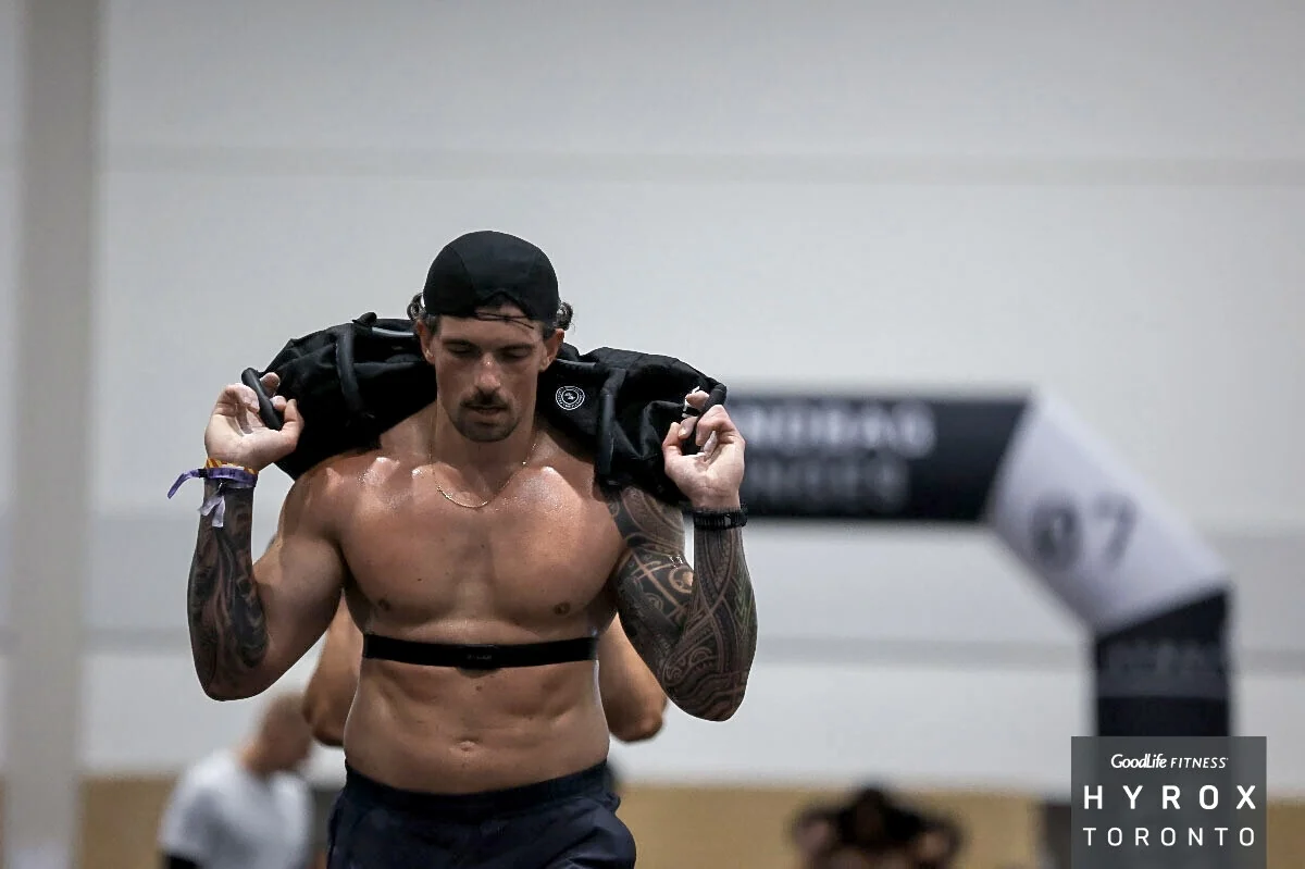 Romain carrying a sandbag during HYROX lunges in Toronto